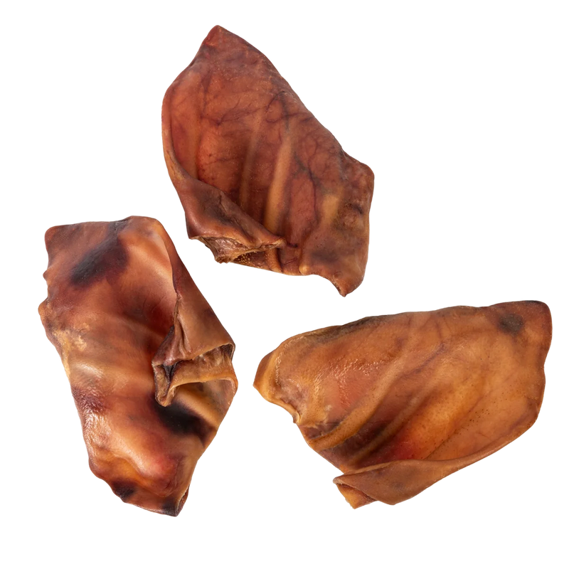 Overhead view of Pig Ears showcasing three brown dog chews on a transparent background