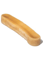 Close up of large Himalayan yak cheese chew dog treat showing dense hard texture and irregular rectangular shape on white background