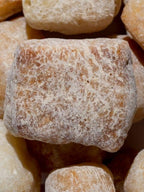Close-up of Peanut Butter Yak Cheese Puffs showcasing crunchy round puffs with visible peanut butter flecks on a dark surface