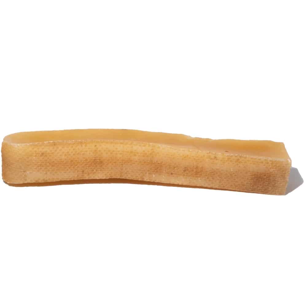Close-up of Himalayan yak cheese chew dog treat showing golden-brown hard pressed texture on white background